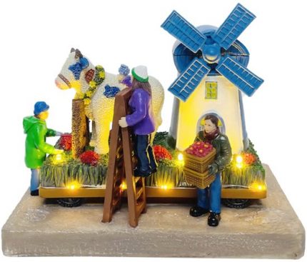 Flower parade with cow at the mill